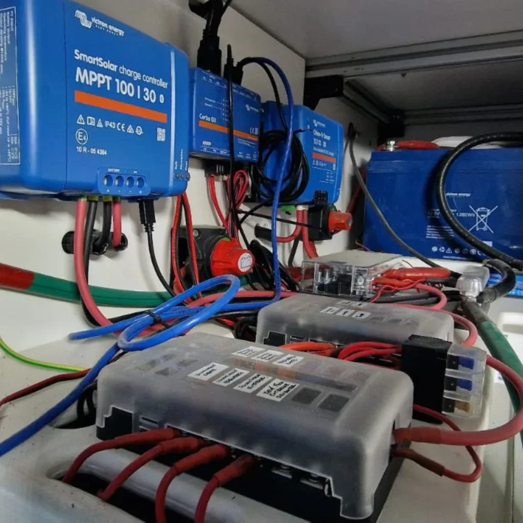 Sistema de gestión de energía con componentes electrónicos y cables en una instalación de vehículo recreativo.