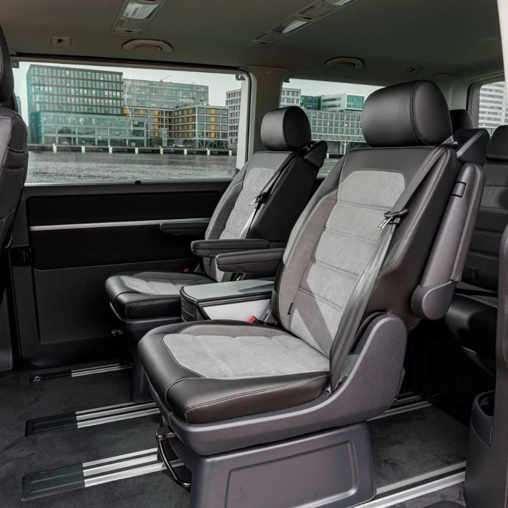 Asientos de coche en un vehículo con vista a edificios urbanos, ideal para homologación y conversiones de furgonetas camper.