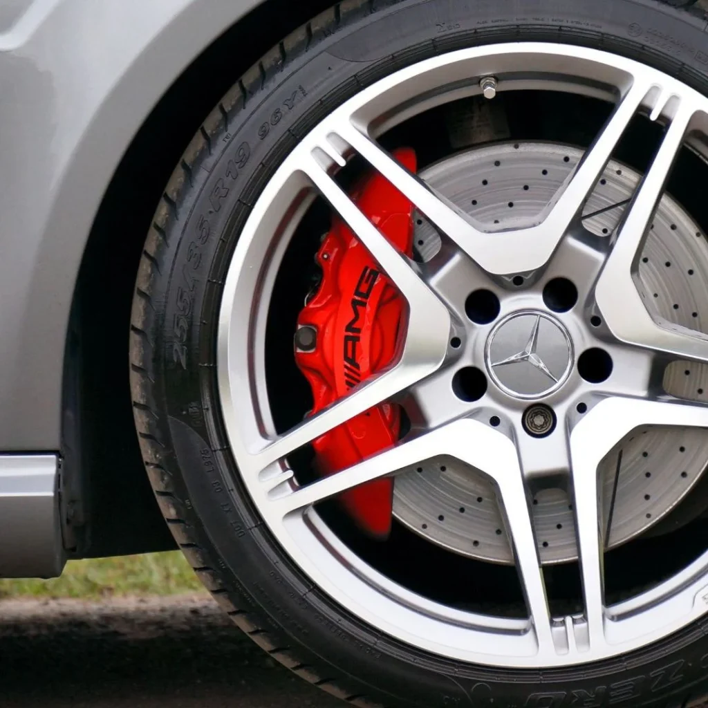 Rueda de coche con llanta de aleación y freno AMG en color rojo, ideal para homologación de vehículos deportivos y conversiones de furgonetas camper.